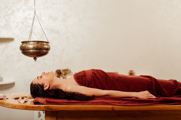 stock-photo-relaxed-young-woman-lying-shirodhara-vessel-ayurvedic-procedure