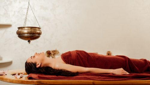 stock-photo-relaxed-young-woman-lying-shirodhara-vessel-ayurvedic-procedure